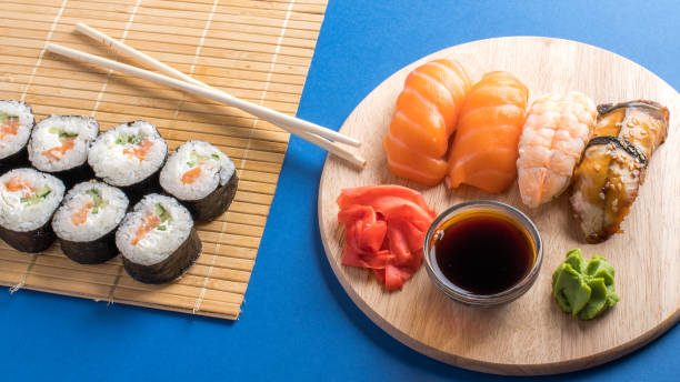 komposition mit köstlichem nigiri-sushi und brötchen - chopsticks soybean japanese cuisine blue stock-fotos und bilder