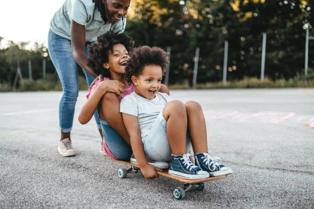 Mother with daughters riding skateboard on playground
