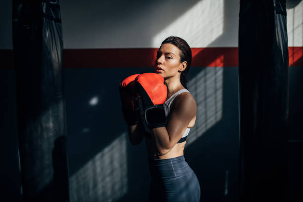 boxeadora femenina sola en el gimnasio - boxing womens fotografías e imágenes de stock