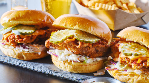 spicy nashville hot chicken sandwich with coleslaw and pickles spicy nashville hot chicken sandwich with coleslaw and pickles in a row crunchy stock pictures, royalty-free photos & images
