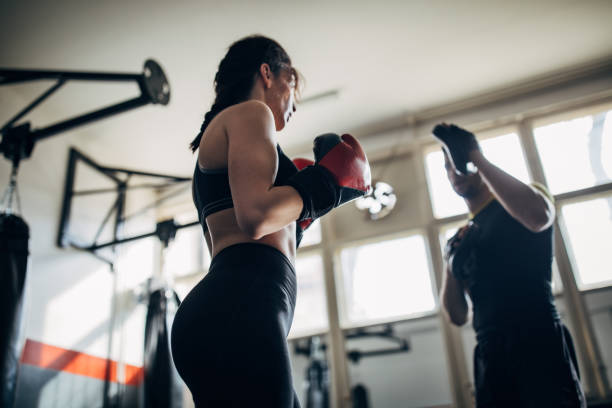 istock Female boxer training with her male coach in gym 1249008497