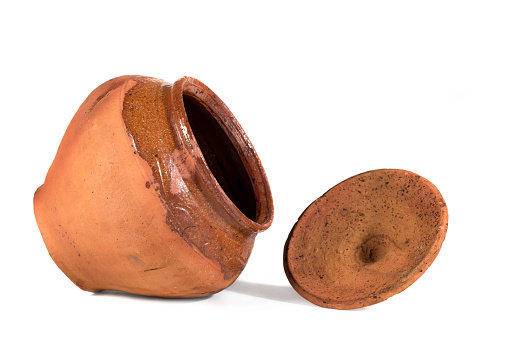 Empty unpainted clay pot on a white isolated background.