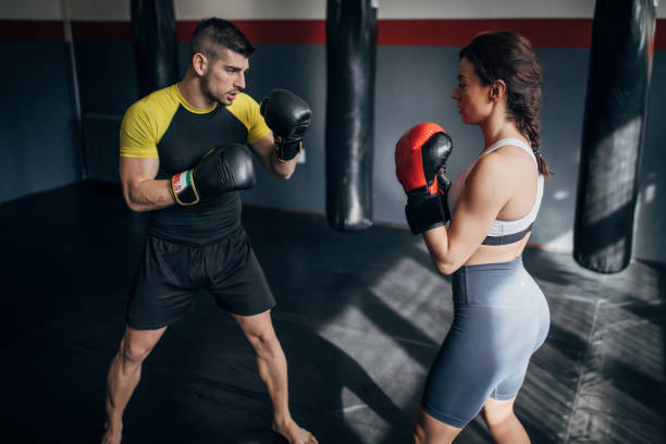 istock Female boxer training with her male coach in gym 1249008544