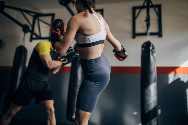 istock Female boxer training with her male coach in gym 1249008741