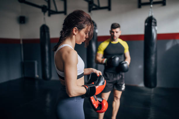 istock Female boxer training with her male coach in gym 1249009629