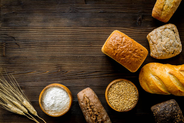 istock Set of different bread with wheat ear on wooden table. Top view 1249011423