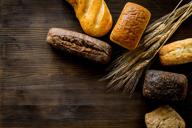 istock Set of different bread with wheat ear on wooden table. Top view 1249011459