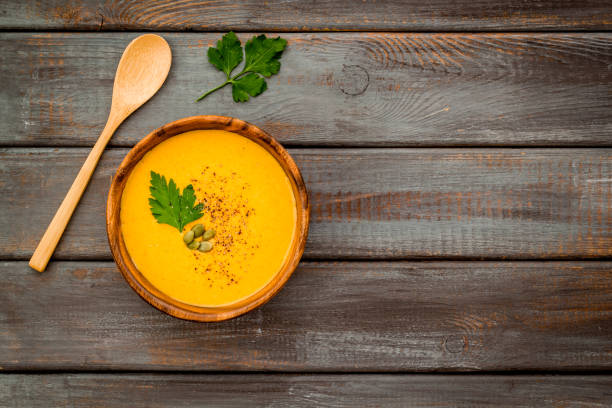 istock Pumpkin soup on dark wooden background top view copy space 1249012948