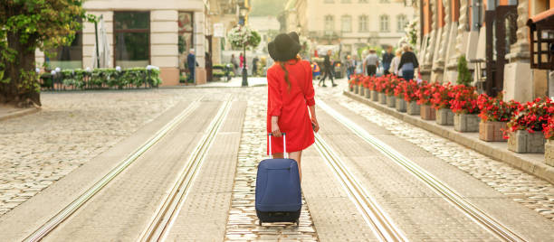 istock Beautiful young girl walking with blue suitcase. 1249013308