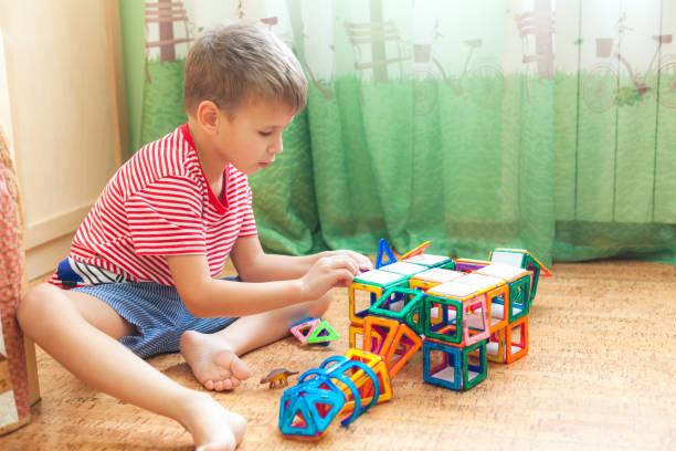 istock Preschooler plays at home sitting on the floor with magnetic constructor. 1249016130