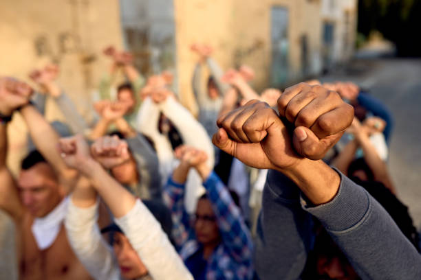 Close-up of crowd of people protesting with clenched fists on the street. Close-up of large group of protesters with clenched fists above their heads on public demonstrations. police brutality photos stock pictures, royalty-free photos & images