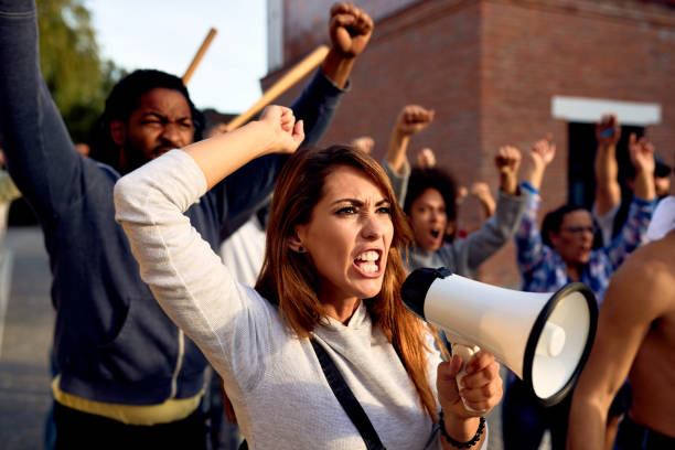 istock Angry woman shouting through megaphone during public demonstrations. 1249018191