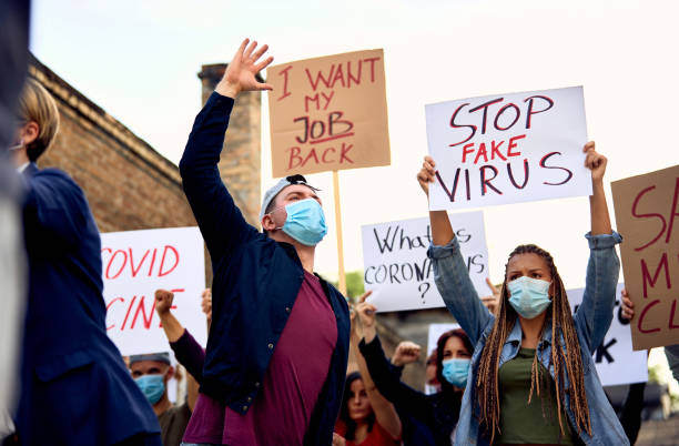istock Below view of people protesting against coronavirus measures. 1249018661