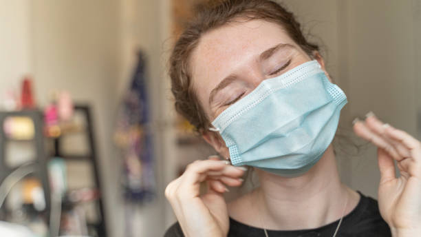 istock 19-years-old adolescent girl wearing a face mask looking into a camera 1249019272