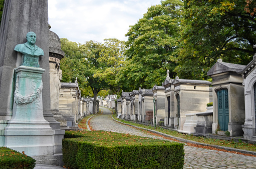 Paris, France - October, 2019: Located in the 20th arrondissement, the Père Lachaise Cemetery is the largest necropolis in Paris and one of the most visited in the world with many famous people buried there. Designed in the English garden style, it's a maze of twisting paths under a canopy of beautiful shade trees.
