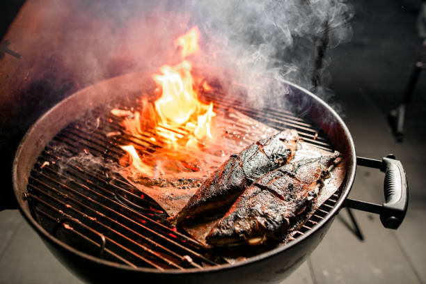 istock Two fish fried on grill of round barbecue. 1249022982