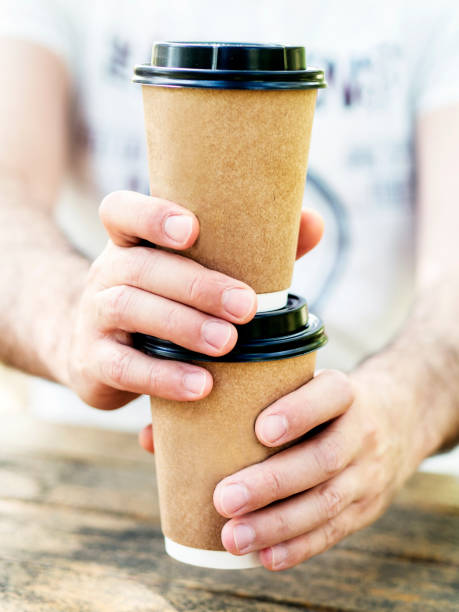 istock young man giving two coffee cups 1249023441
