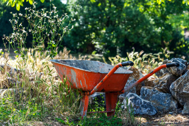 istock Orange colored old wheelbarrow in the garden 1249024163