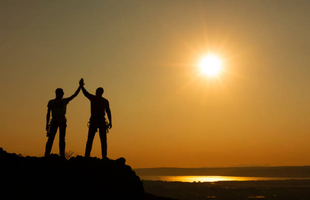istock Couple hikers celebrating success concept in mountains 1249040093