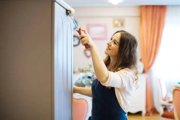 Woman Assembling Wooden Cabinet in Home