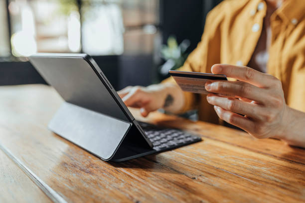 Man Using a Credit Card to Shop Online on his Digital Tablet