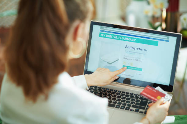 istock woman with empty blister buying pharma using laptop touch screen 1249041709
