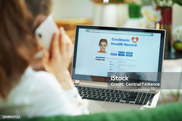 Woman At Home Using Cell Phone And Checking Ehr Stock Photo - Download Image Now - Electronic Medical Record, Patient, Healthcare And Medicine