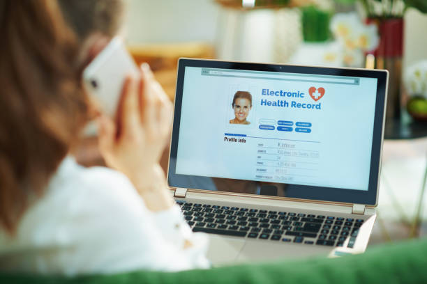 woman at home using cell phone and checking ehr - medical record imagens e fotografias de stock