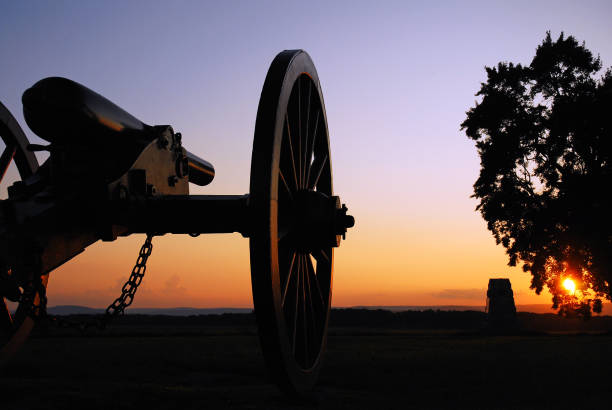 Civil War Cannon at Sunset A cannon from the American Civil War sits silently at sunset at Gettysburg National Battlefield civil war stock pictures, royalty-free photos & images