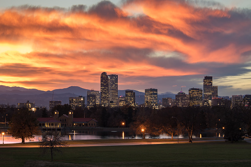 Denver Colorado skyline during sunset, with the Rocky Mountains visible in the background.