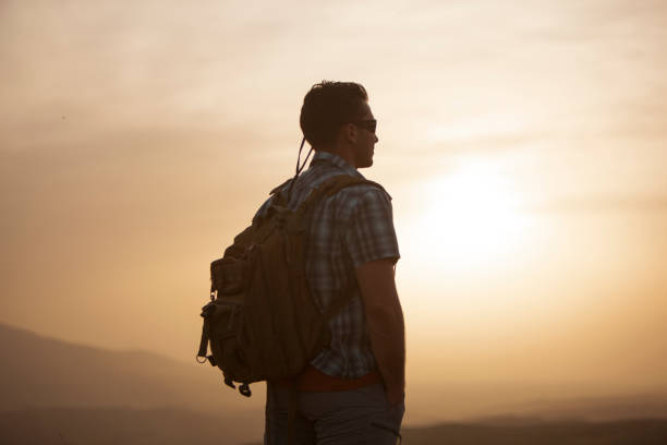 istock man standing in nature at sunset 1249059589