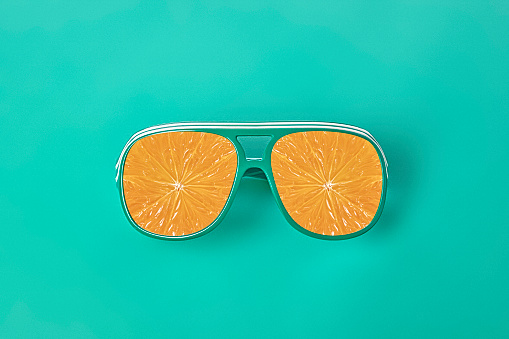 Turquoise Sunglasses on a Turquoise Background with Orange Slices