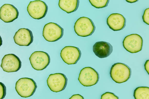 Fresh sliced cucumber repetitive pattern on turquoise abstract pastel background