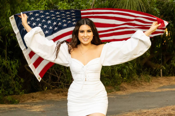 istock Smiling young woman holding a US flag 1249072965