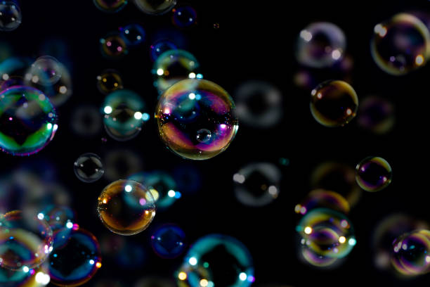 istock Colorful rainbow soap bubbles floating in the dark or black background. bubbles abstract background 1249081443