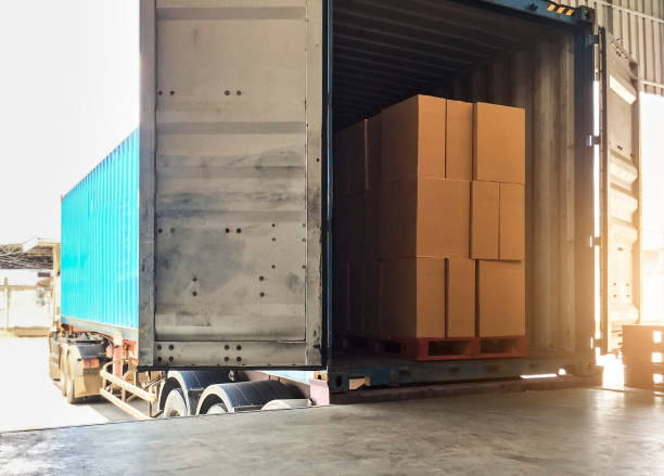 istock Warehouse delivery shipment on road by truck, stack package boxes on pallet load into a truck. 1249081459