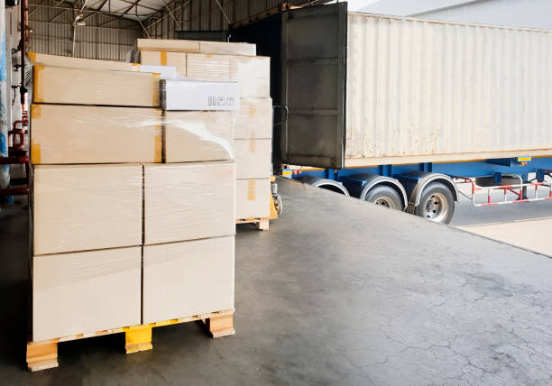 istock Large shipments pallet goods waiting for load into container truck at warehouse dock. Road freight cargo shipment by truck. Logistics and transportation 1249081468