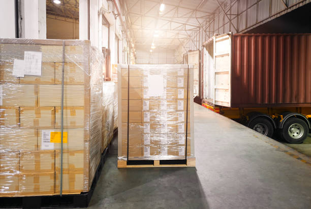 istock Large shipments pallet goods waiting for load into container truck at warehouse dock. Road freight cargo shipment by truck. Logistics and transportation 1249081471