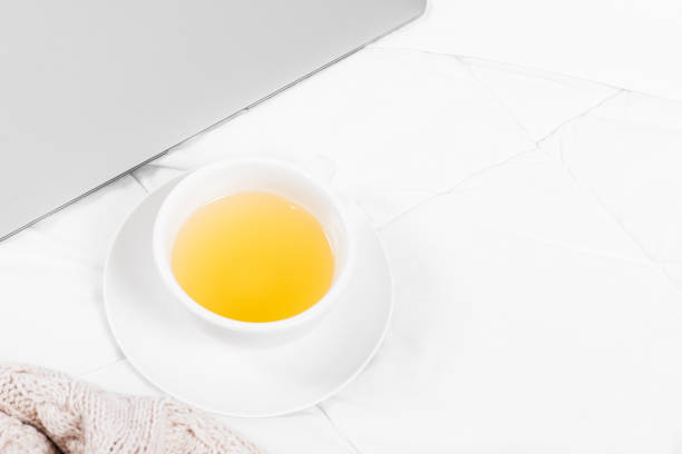 istock Tea, blanket, magazine, and laptop on bed 1249083900