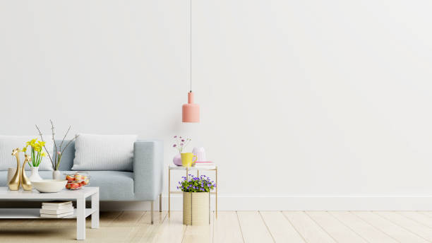 istock Empty living room with blue sofa, plants and table on empty white wall background. 1249085783