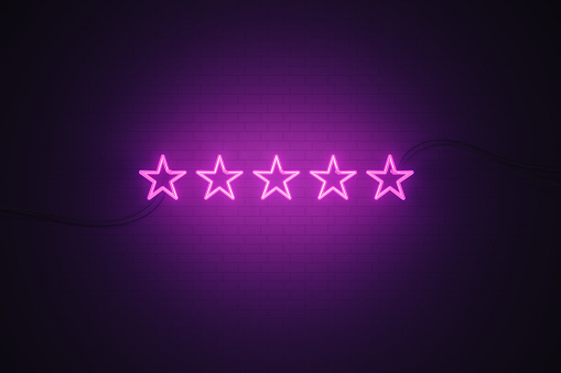 Stars drawn by purple neon light on black wall. Horizontal composition with copy space. Great use for VIP and feedback concepts.