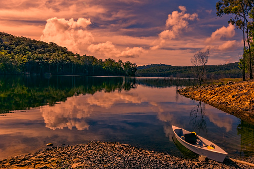 Small canoe on the shore of Hinze Dam in the Gold Coast hinterland of Queensland