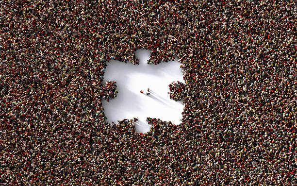 istock Three Men Standing Inside of A Puzzle Shape Which Is Formed  by Human Crowd on White Background 1249090804