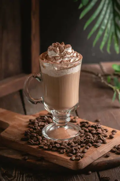 Iced latte coffee with whipped cream on rustic background