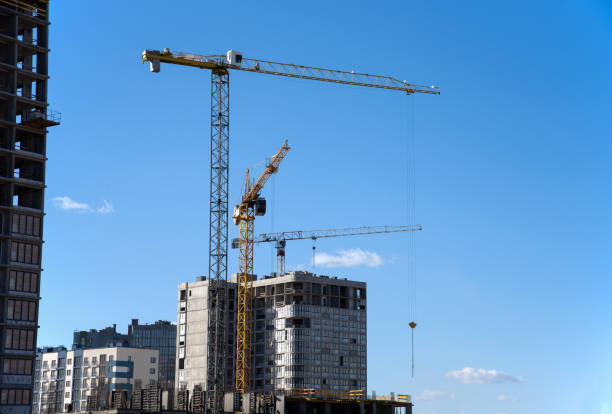 istock Tower crane working at construction site on blue sky background with white clouds 1249106017