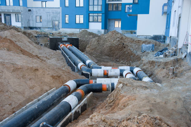 istock Laying heating pipes in a trench at construction site. Install underground storm systems of water main and sanitary sewer. 1249106979