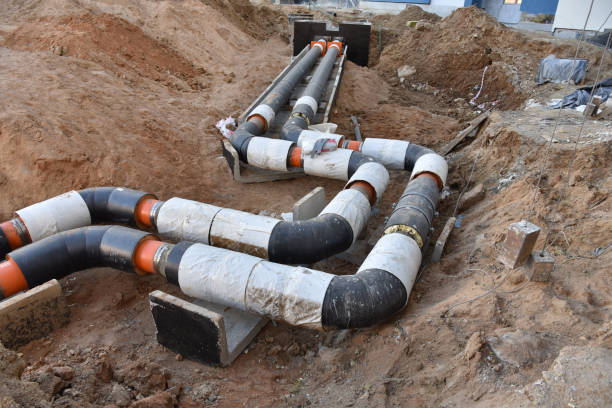 istock Laying heating pipes in a trench at construction site 1249109656