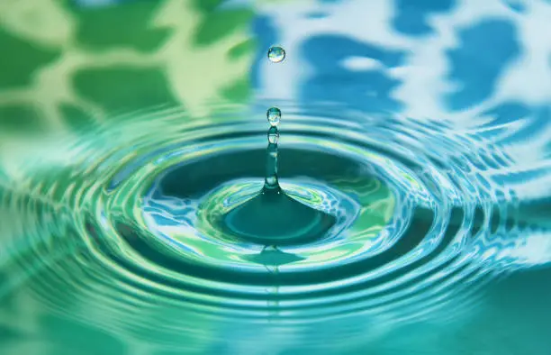 Photo of Water drop falling into water making a perfect concentric circles