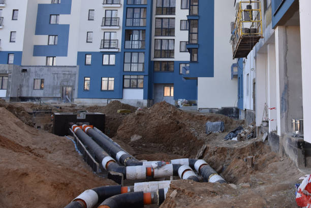 Laying heating pipes in a trench at construction site. Install underground storm systems of water main and sanitary sewer.