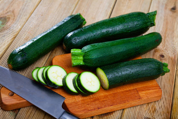 istock Image of cut raw green zucchini on wooden surface 1249111653